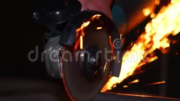 在电锯和工人手上用火花特写在磨床上工作的人接近工具火花飞起来真的视频的预览图