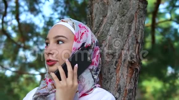 快乐的穆斯林女人在户外移动聊天视频的预览图
