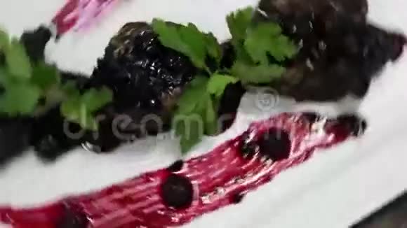 肉被放在白色的盘子里上面装饰着醋栗和欧芹视频的预览图