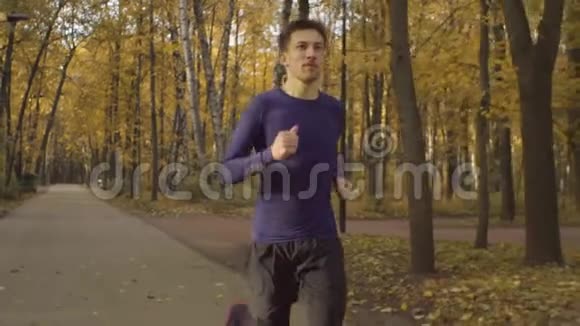 在公园里沿着马路奔跑的年轻人视频的预览图