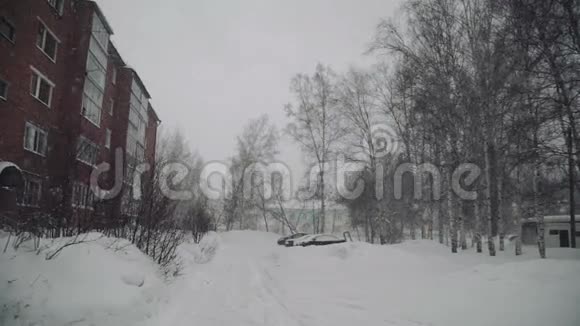 冬天的小镇街上下雪房子平坦树木茂密视频的预览图