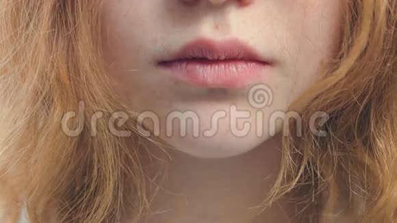 一个有头发和雀斑的女孩的自然嘴唇六月视频的预览图