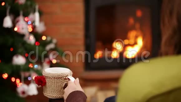 坐在摇椅上的女人坐在壁炉旁放松视频的预览图