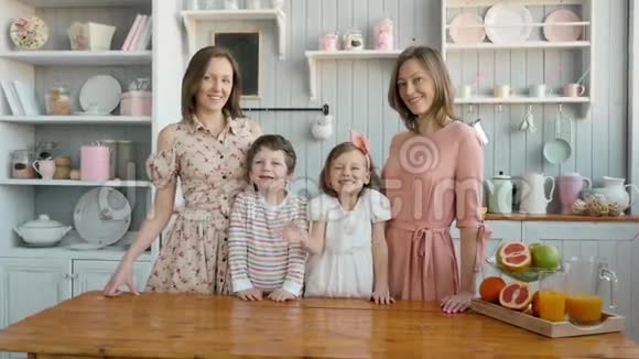 为一个幸福的家庭提供早餐姐妹双胞胎妈妈带着两个孩子女孩和男孩早上吃甜点和水果视频的预览图