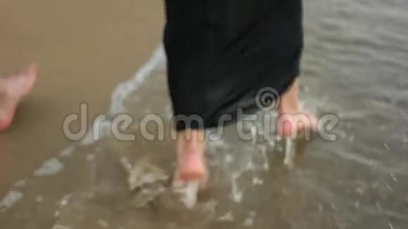一对夫妇光着脚在水里奔跑视频的预览图