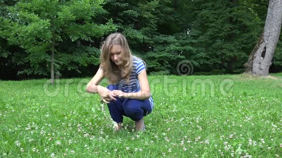 可爱的女人穿着蓝色编织的头花环来自三叶草植物的花4K视频的预览图