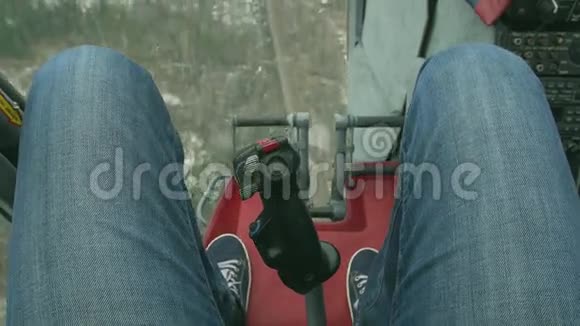 在飞行直升机里看腿摄影师在绿色森林之上一天景观杠杆飞行航班视频的预览图