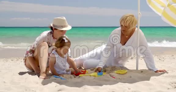 在沙滩上享受乐趣的小家庭视频的预览图