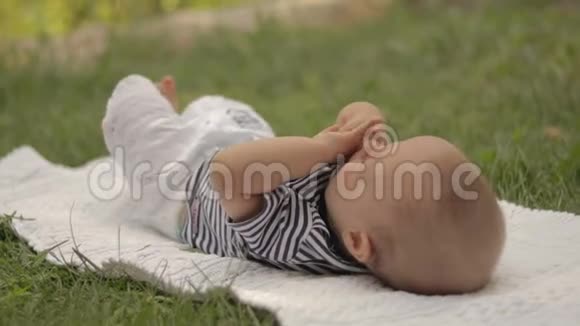 一个小孩躺在草地上玩特写镜头视频的预览图