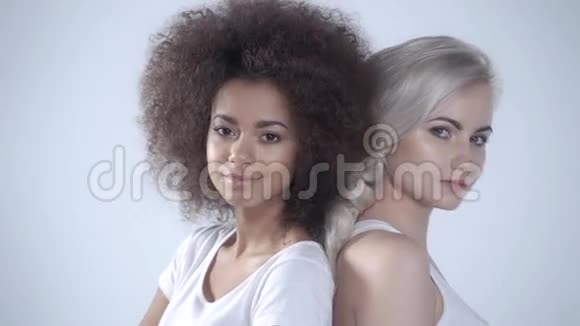 两个幸福的女朋友在白色背景上摆姿势视频的预览图