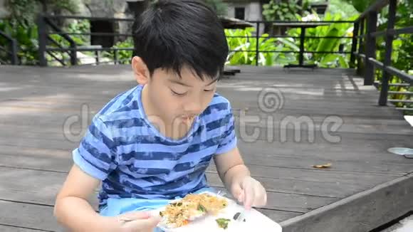 年轻的亚洲可爱男孩在泡沫盒里吃炸辣面视频的预览图