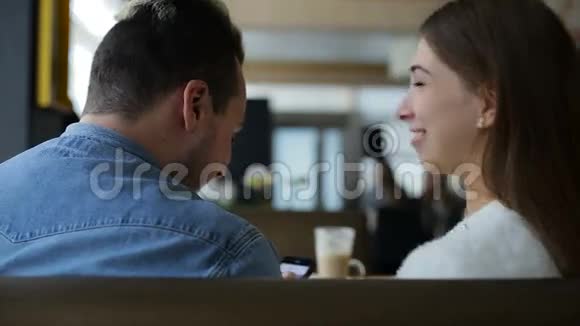 两个笑容可掬的年轻人在咖啡馆里聊天视频的预览图