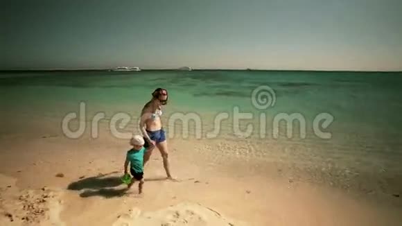 小妈妈和一个小宝宝在海边散步视频的预览图