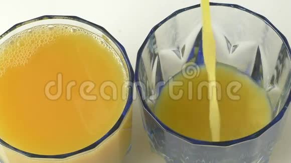 把新鲜橙汁倒在玻璃杯里的人视频的预览图