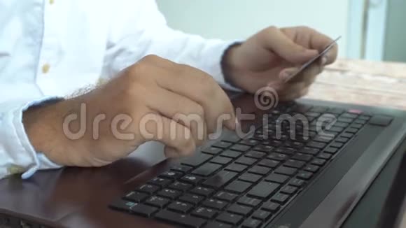 男人在线支付在笔记本电脑上插入信用卡号码网上银行视频的预览图