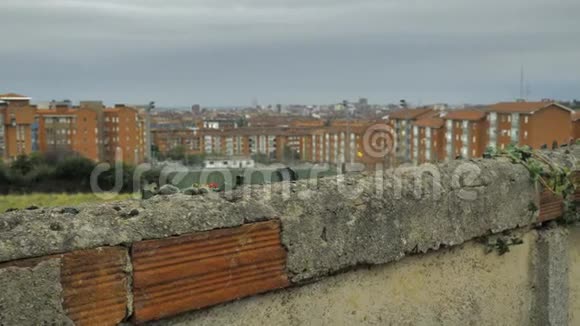 旧的石栅栏顶部和市区背景上有尖锐的撞瓶视频的预览图