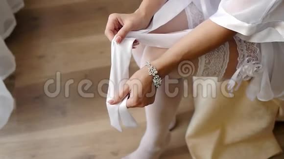 新娘在卧室里为婚礼准备长统袜侧射视频的预览图