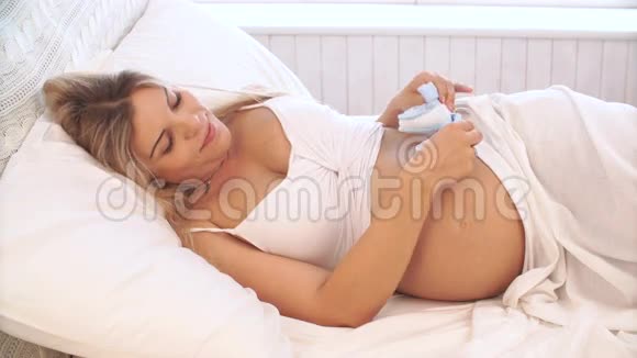 孕妇在肚子上玩婴儿鞋视频的预览图