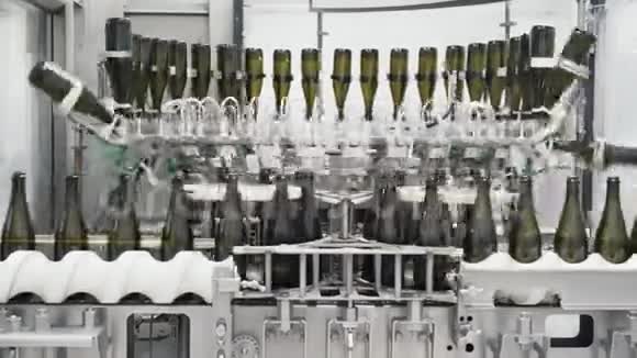 在香槟或葡萄酒工厂绿色瓶子沿着自动化生产线移动视频的预览图