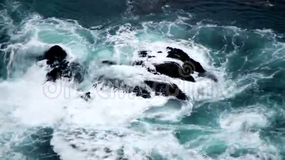 巨大的波浪在岩石上翻滚视频的预览图