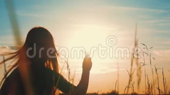 快乐的小女孩在日落时在户外玩纸飞机日落时剪影概念大梦想视频的预览图