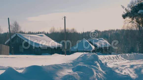 森林里的冬村白雪覆盖了木屋的屋顶视频的预览图