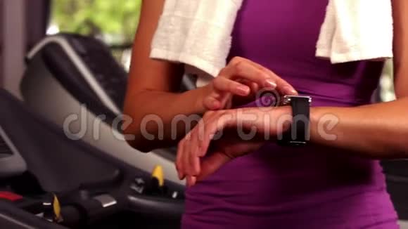 适合女人在跑步机上用一只连接的手表跑步视频的预览图