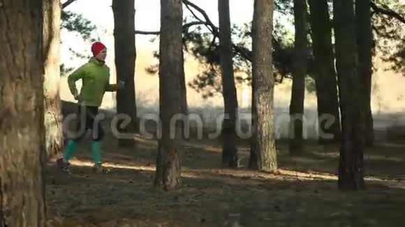 在阳光明媚的日子里女人在森林跑道上奔跑视频的预览图