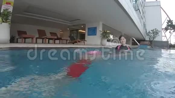 母亲教女儿在游泳池游泳视频的预览图