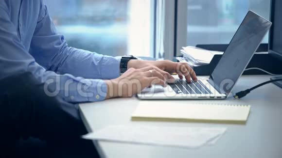 男人用手在笔记本电脑键盘上打字视频的预览图
