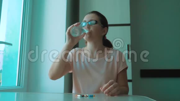 女孩在家吃药是生病的慢动作视频保健和医学概念疾病女人吃了药视频的预览图