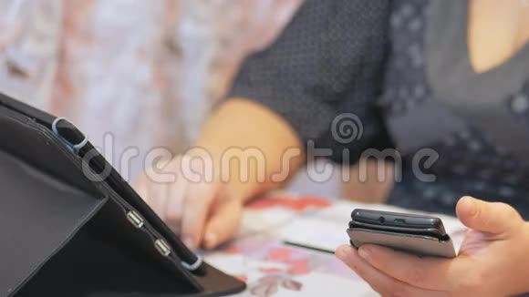家庭主妇在家庭生活中通过智能手机和平板信用卡进行网上银行业务视频的预览图