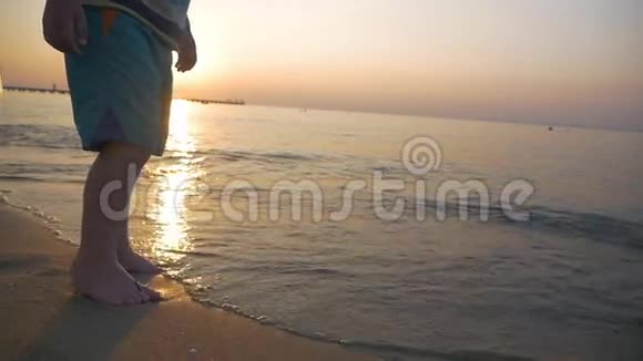 日落时赤着脚在海边奔跑的孩子视频的预览图