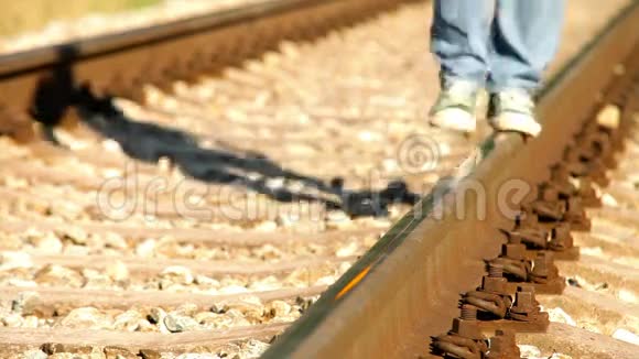 一个十几岁的少年穿着运动鞋在铁路上漫步视频的预览图