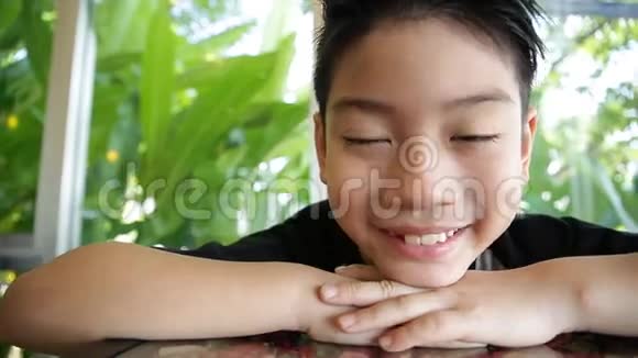 绿叶的亚洲小孩快乐的面部表情视频的预览图