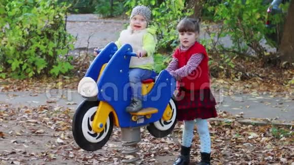 小女孩骑着木制摩托车玩妹妹视频的预览图