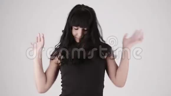 美丽的拉丁裔女人在浅灰色的背景下快乐地跳舞复制空间文本视频的预览图