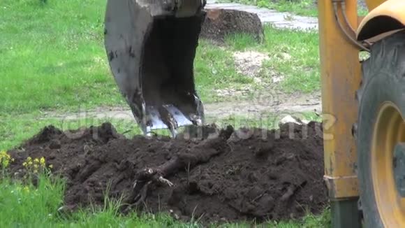 一辆挖掘机在草坪上挖洞视频的预览图