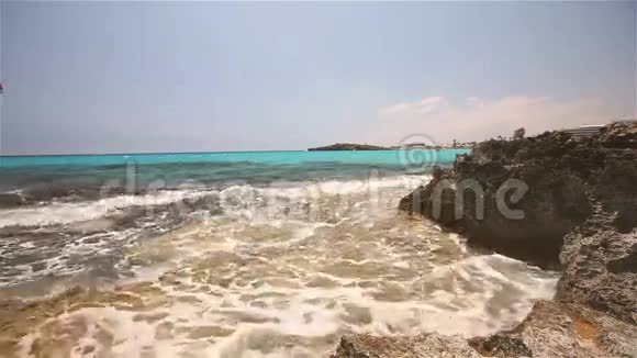 蔚蓝的大海一片虫族的海洋在海岸线的背景下海浪拍打着岩石海岸视频的预览图