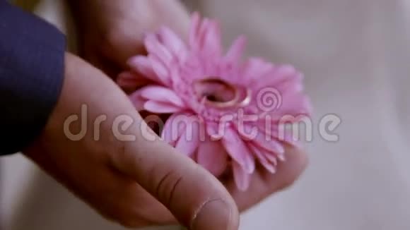 新郎手里拿着戒指戴在一朵花上视频的预览图