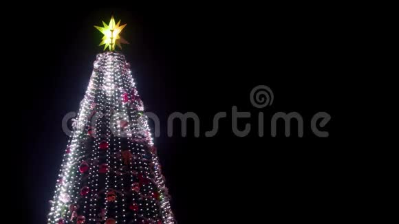 在下雪的冬夜城市广场上有发光的花环和装饰的大型圣诞树特写镜头发光视频的预览图