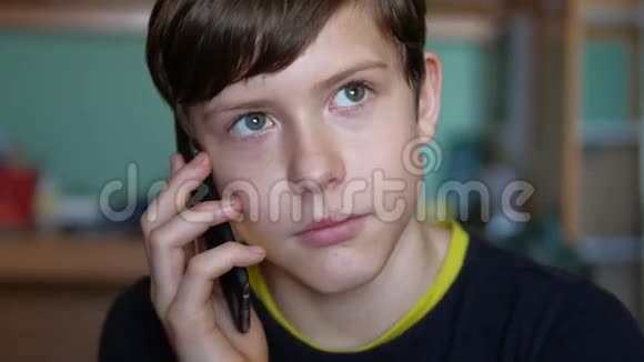 十几岁的男孩在室内智能手机上打电话视频的预览图
