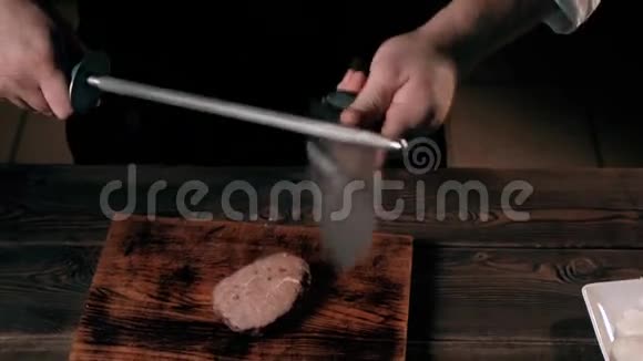 商用厨房中男厨磨刀的切割视频的预览图