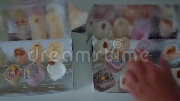 女人的手把美丽的东方糖果放在包裹上视频的预览图
