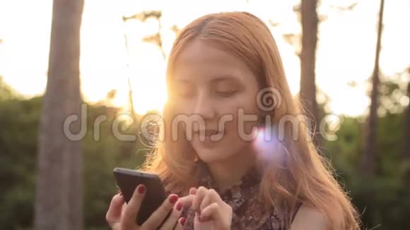 微笑的快乐女孩用电话和看镜头的肖像视频的预览图