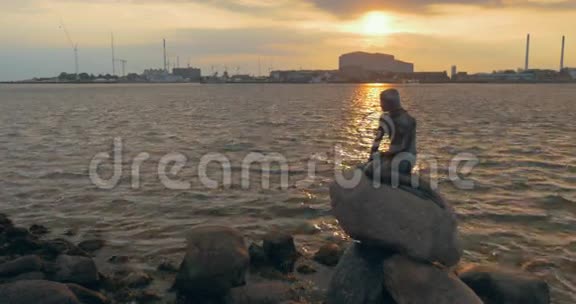 日落时分城市水边的美人鱼雕像视频的预览图