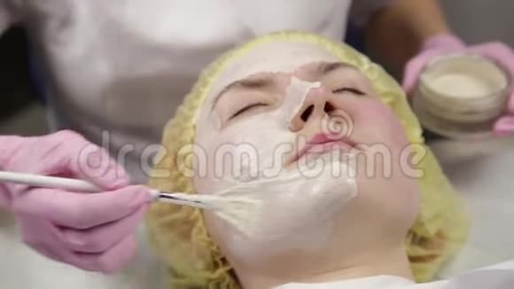 美容师把面膜敷在问题皮肤上清洗皮肤的年轻妇女视频的预览图