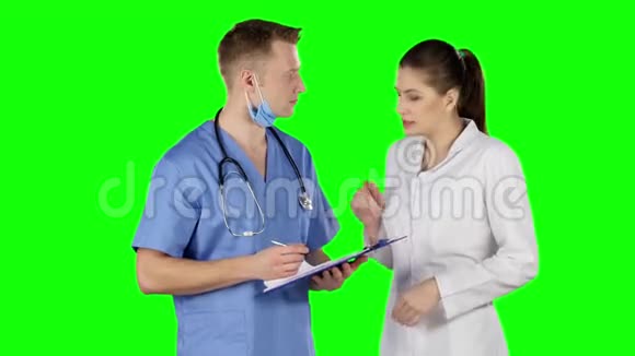 两个医生用剪贴板说话绿色屏幕视频的预览图