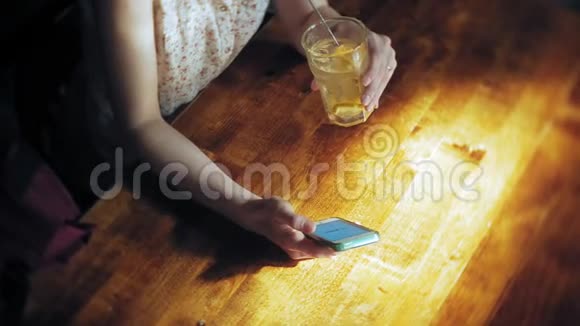 一个女人在餐馆喝鸡尾酒用电话视频的预览图