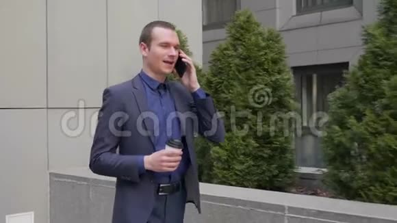 一个年轻的商人走在街上通过电话交谈视频的预览图
